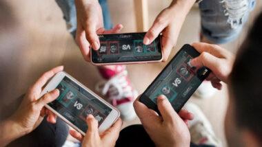 Three people playing an online multiplayer mobile game on smartphones